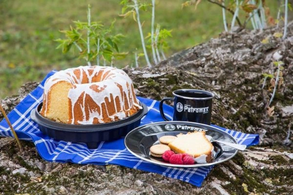 Picnic cu tava cu chec, cana Petromax si farfurie Petromax cu bucata de chec, zmeura si biscuiti